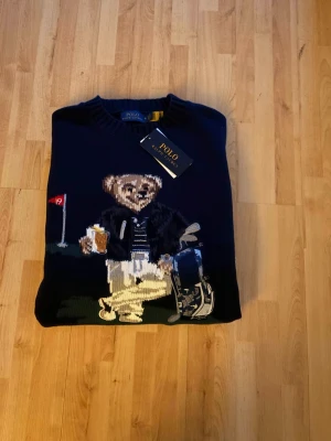 Ralph lauren bear sweater Ny-oanvänd - Säljer en helt ny och oanvänd Ralph Lauren Bear Sweater. Den ikoniska Polo Bear-designen ger en tidlös och exklusiv look. Tröjan är i hög kvalitet med mjukt och bekvämt material, perfekt för både vardag och finare tillfällen. 🔹 Märke: Ralph Lauren 🔹 Modell: Bear Sweater (Polo Bear) 🔹 Skick: Helt ny / oanvänd 🔹 Passform: Klassisk Nypris är högt – perfekt chans att fynda! Hör gärna av dig vid frågor eller om du vill ha fler bilder.
