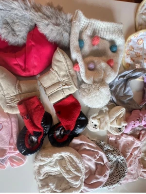 Mixade babyaccessoarer mössor & vantar stl 56  - Säljer ett blandat paket med babyaccessoarer, inklusive vita stickade mössor med tofs och färgglada bollar, rosa och lila stickade mössor, samt flera par små vantar i olika färger och material. Perfekt för att hålla de minsta varma och söta under kalla dagar. Du är varmt välkommen att kika på mina andra annonser