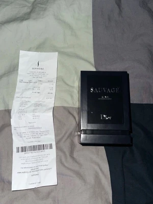 Dior Sauvage Elixir parfym - Dior Sauvage Elixir är en exklusiv herrparfym i en elegant, mörkblå glasflaska med silverdetaljer. Flaskan har en rund form och kommer i en lyxig svart förpackning med tydlig logga. Doften är intensiv och maskulin, perfekt för dig som vill sticka ut.