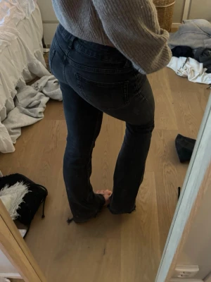 Svarta straight jeans med hög midja - Snygga svarta jeans med hög midja och raka ben. Jeansen har klassisk femficksdesign och knappgylf. Perfekta till en avslappnad och trendig look.