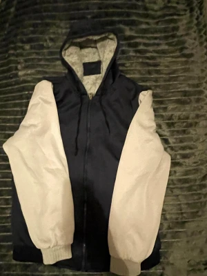 Svart hoodie med vita ärmar - Perfekt hoodie för då de är kallt då den är väldigt varm av sig.  Mjukt på insidan 