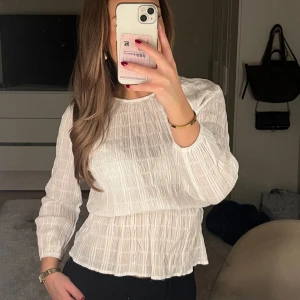Blus - Vit tunn blus med stuktur från NA-KD. Blusen är i bra skick och är i storlek xs. Den är även i väldigt stretchigt material vilket gör den lätt att ta på och av. 💕