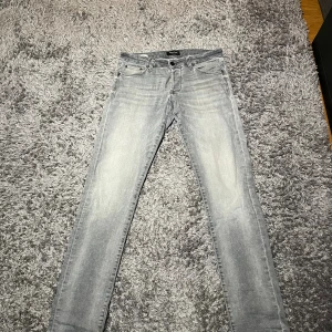 Grå jeans Jack & Jones - Snygga ljusgrå jeans från Jack & Jones. Modellen är slim och eftersom de är superstrech är de väldigt sköna att ha på sig! Perfekta nu för vintern. W31 men kan passa större pga stretchen. Tveka inte att köra av dig vid frågor!