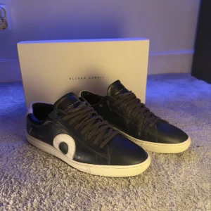 Mörkblåa Oliver Cabell Skor - Snygga mörkblåa sneakers från Oliver Cabell i skinn med vita detaljer och rund tå. Skorna har en vit sula och mörka snören. Perfekta för dig som gillar stilrena men ändå unika sneakers. Skriv om du har frågor eller behöver fler bilder!