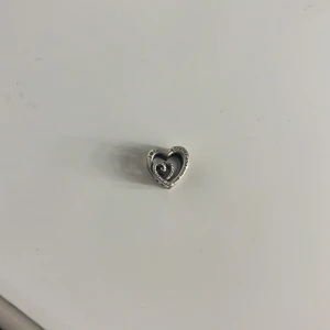 Pandora Sammanflätade Evighetshjärtan Berlock   - En Pandora berlock med texten "mom" och "i love you for ever and ever....". Berlocken är tillverkad i sterling silver. Berlocken har använts fler gånger.