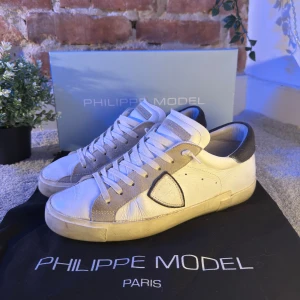 Vita Philippe Model skor - Tja, säljer mina vita Philippe Model skor. Nypris är ca 3200 kr. Skicket är väldigt bra på skorna. Hälen av skorna är mörkblå mocka, samt färgen runt loggan. Sulorna är i väldigt bra skick, knappt några märkningar på användning. Original box och påse ingår. Skriv för fler bilder eller funderingar! 