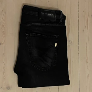 Dondup svart - Säljer dessa svarta eftertraktade dondup jeansen med sjukt snygga slitningar! Dem är i storlek 30 (passar mig som har 29) och är i ett gott skick. !OBS! Dem är omsydda på längden (var kortare innan, kika sista bild). Ingenting som märks när jeansen sitter på då det stackar! Ställ gärna frågor eller be om fler bilder ifall du är osäker🤗