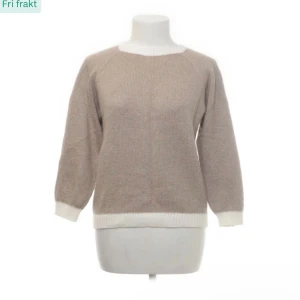 Beige stickad tröja med vita detaljer - Mysig beige stickad tröja med vita ribbade kanter vid hals, ärmslut och nederkant. Tröjan har en rund halsringning och långärmade raglanärmar. Perfekt för dig som gillar enkel och stilren design med en soft vibe.100 % Kashmir 