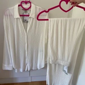 Vit plisserad matchande skjorta och byxa - Säljer en vit plisserad skjorta och byxa från H&M helt nya med prislappar på, båda i storlek S super fina 