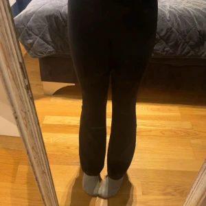 Svarta yoga pants från H&M Divided - Svarta yoga pants från H&M Divided Basic, med smal passform upptill och lätt utsvängda ben. Mjukt och stretchigt material som sitter skönt och följer kroppen. Perfekta för dig som gillar en enkel och stilren look.
