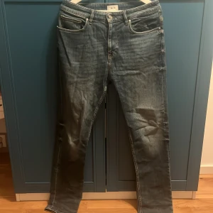 Blå jeans från NN07 med straight fit - Säljer ett par snygga blå jeans från NN07 med klassisk femficksdesign och läderpatch bak. Jeansen har en rak passform och är tillverkade i slitstarkt denimtyg med snygg tvättad look. Perfekta för dig som gillar stilrena och tidlösa jeans. original pris 1400