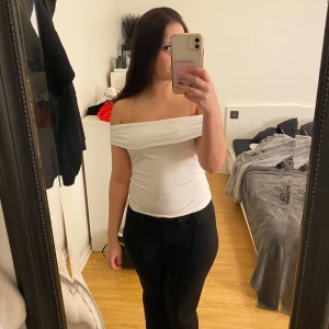 Vit offshoulder topp från SHEIN - Säljer en vit offshoulder topp från SHEIN i storlek S. Toppen har en bred, vikt kant över axlarna och är figurnära med stretchigt material. Den är ärmlös och har en clean, stilren look som är enkel att matcha med olika outfits.