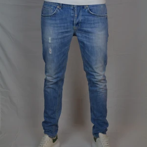 Dondup George - Feta blåa Dondup jeans med en slitning på höger lår. Jeansen är i modellen George, storlek 32 och är i väldigt gott skick, dvs har inga tecken på användning.                                Innerbensmått:78cm            Midjemått:42cm                                                              Vid frågor eller funderingar är det bara att höra av sig, och kom ihåg, alltid 14 dagars ångerrätt hos oss på Revalo!