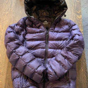 Mörklila pufferjacka från Equiline - Säljer en mörklila pufferjacka från Equiline med huva och dragkedja framtill. Jackan har ett quiltat mönster och är tillverkad i syntetmaterial. Perfekt för kalla dagar och har en cool look. NYPRIS 2000