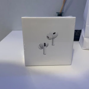 AirPods Pro (2nd generation) with MagSafe Charging Case (USB-C) - Helt nya och oöppnade AirPods Pro (2nd generation) med MagSafe-laddningsetui (USB-C). Aktiv brusreducering, transparensläge och förbättrad ljudkvalitet. Perfekt för musik, samtal och träning. Levereras i originalförpackning, plasten är obruten. Fick dessa i födelsedagspresent men hadde redan precis köpt AirPods Pro 3