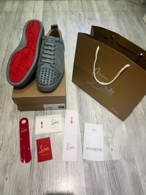 Christian Louboutin grå - Hej. Jag säljer nu ett par gråa Christian Louboutin skor. Anledningen till försäljningen är att jag inte har behov av dem då jag brukar mest ha mer bekväma sportskor. Jag har köpt dem i NK i Göteborg. Skorna ingår med tillbehören i annonsen. De passar som 43. Skriv gärna till mig om du har en fundering! 