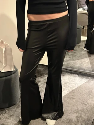 skinnbyxor lågmidjade bootcut med spelskant - utsvängda skinnbyxor med spetskant på sidan. jag är 175 cm lång som referens! hör av er vid frågor!! bästa festbyxan 👏🏼