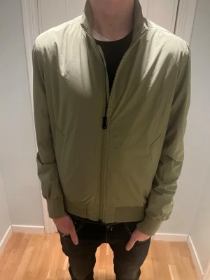 J Lindeberg vindjacka - Ljusgrön jacka från J Lindeberg. Helt ny med lapp kvar. Nypris är ca 3000. Perfekt för våren eller hösten. 