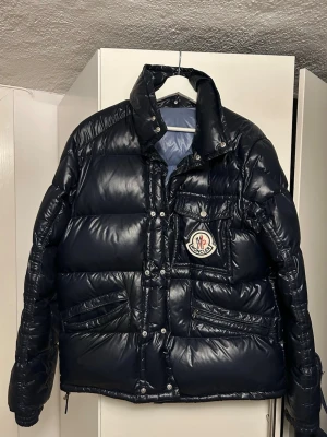 Äkta Moncler jacka navy  - Äkta moncler jacka navy blue storlek L/4 ,orderbekräftelse finns, kan gå ned i pris vid snabbaffär, saknas bara 1 dragkedja på en av fickorna där fram