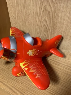 Charlie Björn Flygplan - Bilderna visar en leksaksflygplan, inte en väst. Kan därför inte ge någon beskrivning av sopassande väst.