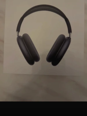 AirPods Max - Apple AirPods Max i svart färg, over-ear hörlurar med aktiv brusreducering och hög ljudkvalitet. Levereras med original Smart Case och USB-C. Hörlurarna och fodralet ser ut att vara i mycket gott skick utan synligt slitage. Perfekt för musik, film och samtal.