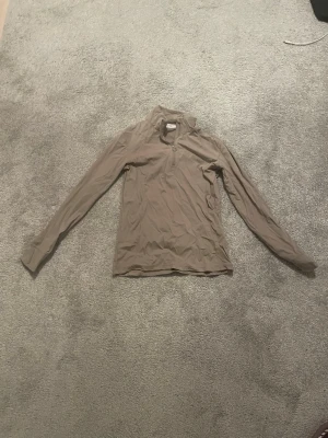 Beige långärmad ridtopp PS of Sweden - Säljer en beige långärmad träningstopp från PS of Sweden i storlek S. Toppen har en liten krage och halv dragkedja framtill. Materialet är stretchigt och känns sportigt, perfekt för aktiva dagar eller ridning. Hittar tyvärr inte den på deras hemsida och har glömt bort hur mycket den kostar men tror att de va mellan 400-500. Inga skador eller hål, tvättad självklart innan den skickas.