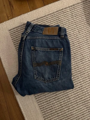 Nudie Jeans Gritty Jackson Blue Slate - Säljer ett par Nudie Jeans Gritty Jackson i färgen Blue Slate. Klassiska blå jeans med rak passform och snygga kontrastsömmar på bakfickan. Populär tvätt i storlek 29/32