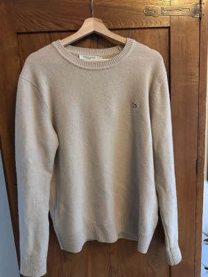 Maison Kitsuné sweatshirt - Säljer en beige stickad tröja från Maison Kitsuné med den klassiska räven. Nypris: 3400