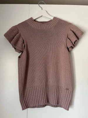 Stickad volangtröja Holly & Whyte - Säljer en supersöt rosa stickad tröja från Holly & Whyte by Lindex. Helt oanvänd. Storlek M men passar även S. Den är oanvänd!