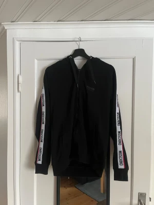 Moschino Hoodie - Moschino underwear hoodie som inte kommer till användning längre. Finns ett litet håll i ärmen men syns inte. Kan skicka vid intresse. Storlek M. Nypris ca 3000 mitt pris 1099