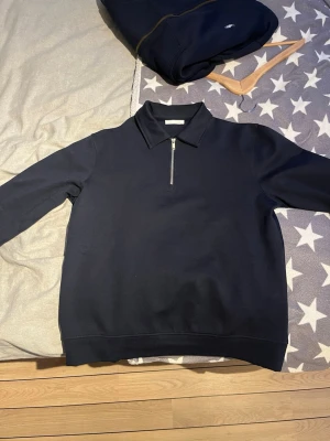 Mörkblå half zip tröja från Zara - Svart långärmad tröja från Zara med krage och half zip-dragkedja framtill. Tröjan har en clean och stilren look, perfekt till jeans eller chinos. Tillverkad i mjuk bomull som känns skön mot huden.