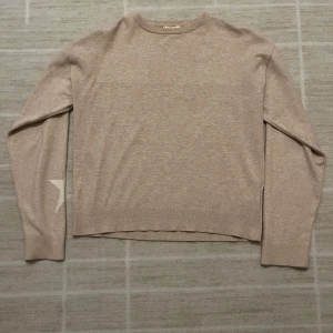 Beige stickad tröja med stjärna Gina Tricot - Beige stickad tröja från Gina Tricot i storlek 158/164. Tröjan har rund halsringning, långa ärmar och en vit stjärndetalj på varje ärm. Inte använd så många gånger