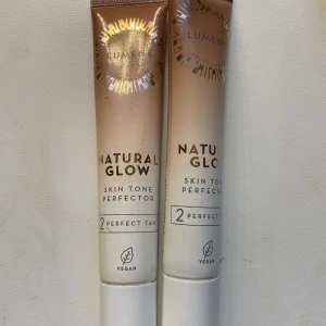 Lumene Natural Glow Skin Tone Perfector - Aldrig använda!!! Två tuber Lumene Natural Glow Skin Tone Perfector i nyansen 2 Perfect Tan. Ger en naturlig lyster och jämnar ut hudtonen. Vegansk formula i snygg beige och guld förpackning. Perfekt för dig som vill ha en fräsch glow och lätt täckning.