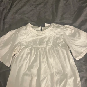 Vit broderad blus från Zara - PRIS KAN DISKUTERAS! Supersöt vit blus från Zara med broderade detaljer och spetsinslag upptill. Blusen har korta ärmar och en lätt rynkad passform under bysten. Perfekt för dig som gillar romantiska och feminina vibes. 