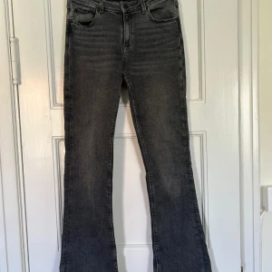Bootcut svarta jeans - Säljer ett par svarta bootcut jeans med klassisk femficksdesign och snygga slitningar framtill. Jeansen har en mörk tvätt och är tillverkade i mjukt denim som sitter skönt. Dem har även en snygg öppning längst ner på jeansen🖤🖤🖤