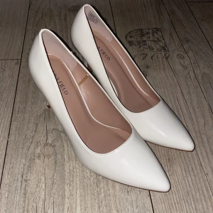 Vita pumps från Anna Field med klack - Snygga vita pumps från Anna Field med spetsig tå och hög klack. Skorna har en stilren design i syntetmaterial och en klassisk siluett som ger en elegant look. Perfekta för dig som vill sticka ut med en fräsch och clean stil. 8cm klack och aldrig använda💕