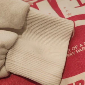 Vit hoodie med rosa björntryck - Vit hoodie med stor huva och magficka. På bröstet och ryggen finns ett rosa tryck med Lotso-björn från Toy Story, texten 'You are mine' och jordgubbar. Mjuk bomullskänsla och ribbade muddar. Inte nopprig eller några defekter förutom lite bort tvättat i vissa små delar på trycket. Säljer för att den blev för liten. Nypris ca 500. Köpt utomlands.💞💞