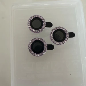  Dekoration till mobil  -  Dekoration till mobil som är i färgen lila med stenar på. Storlek 11pro/11pro max iPhone