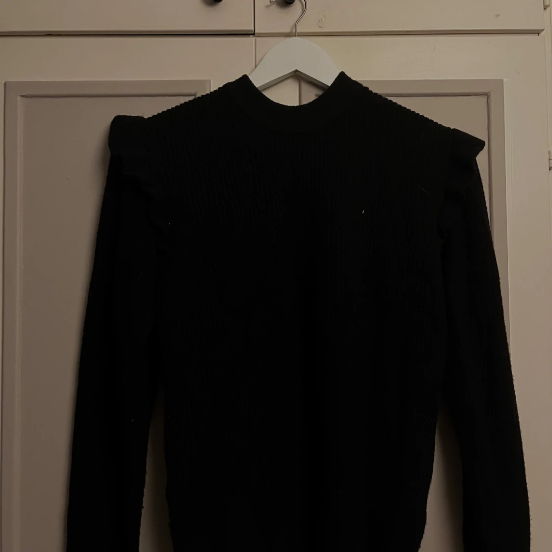 Svart stickad tröja med volanger