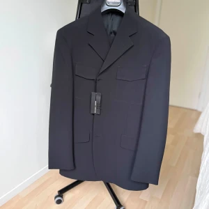 Svart kostym – Mediterranea, Made in Italy (stl 50) - Elegant svart kostym från italienska Mediterranea. Klassisk tvåknäppt modell med matchande byxor och helfodrad insida. En tidlös modell som fungerar lika bra till vardags som till fest och bröllop.  Storlek: 50  Färg: Svart (col. 12)  Märke: Mediterranea – Made in Italy  Nypris: 4195 kr  Skick: Ny med tags