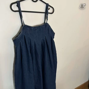 Blå jeansklänning från SHEIN - Säljer en blå jeansklänning från SHEIN i storlek L. Klänningen har smala axelband, veckad kjol och dragkedja i sidan. Perfekt för dig som gillar en avslappnad och trendig look. Materialet är klassiskt denim och modellen är luftig och bekväm.