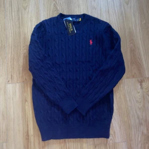 Mörkblå stickad tröja Polo Ralph Lauren - Mörkblå stickad tröja från Polo Ralph Lauren. Aldrig använd därför är den i nyskick. Storlek S men passar XS. 