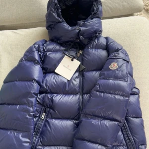 Moncler Maya strl 2 - Säljer nu ett av mina favorit plagg! Moncler Maya i strl 2. Den sitter perfekt för dig som använder M och den är perfekt färg för att sticka ut litegrann. Säljer den för jag har tröttnat lite på den och vill helt enkelt testa något nytt! Har använt den under förra vintern. Köpt från plick innan för 5900kr. Skick 8/10! 