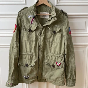 Field jacket Adrian Hammond - Tja! Säljer min field jacket från Adrian Hammond! Den är endast använd en handfull gånger. Många feta patches och text runt hela. Tveka inte på att höra ev er vid frågor!