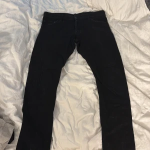 Svarta jeans från Dsquared2 - Säljer ett par svarta Dsquared2 Sexy Twist jeans i klassisk femficksmodell. Jeansen har en snygg, smal passform och är tillverkade i bomullsdenim. Stilsäkra detaljer som svarta nitar och Dsquared2-läderpatch bak. Perfekta för dig som gillar en clean och modern look.