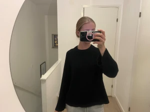 Svart stickad tröja från Gina Tricot strl S - Svart stickad tröja från Gina Tricot i ullblandning. Tröjan har rund hals, långa ärmar och breda ribbade muddar vid ärmslut och nederkant. Passformen är loose och modellen är enkel och stilren. 