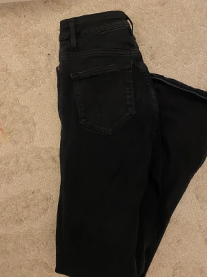 Svarta jeans med hög midja - Snygga svarta jeans med klassisk femficksdesign och hög midja. Jeansen har raka ben och är tillverkade i ett mjukt denimtyg som sitter skönt hela dagen. Perfekta till sneakers eller boots för en clean look.