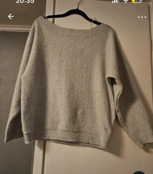 Beige stickad tröja från Nelly - Mysig beige stickad tröja från Nelly i storlek M. Tröjan har en loose passform med bred halsringning och långa ärmar. Perfekt för att hålla sig varm under kyliga dagar. Ribbstickade muddar vid ärmslut och nederkant ger en snygg detalj.