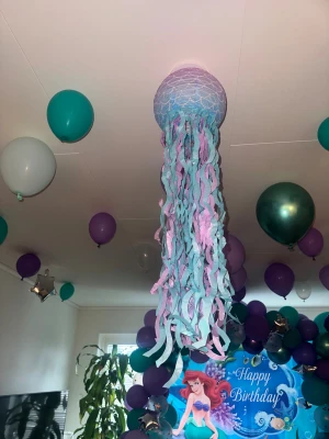 Medusa papperslykta med expander Ariel Disney akvarium - Medusa papperslykta med expander Ariel Disney akvarium  Färgglad papperslykta i form av en medusa, perfekt för barnkalas eller temafest. Lätt att montera med medföljande expander. Fint skick, inga synliga skador. Skapar en festlig undervattensstämning med lila och turkosa toner