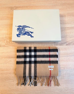 Burberry rutig kashmirhalsduk beige - Burberry Scarf - 100% cashmere, classic beige check pattern, with a Burberry Prorsum collector's box. This elegant, luxurious Burberry scarf is made of 100% premium cashmere. Featuring the iconic beige House Check pattern with a distinctive red accent, it's one of the brand's most recognizable and timeless designs. This piece is from an older Burberry collection, as evidenced by the original box with the Equestrian Knight / Burberry Prorsum logo.  More information ánd can be obtained by message 